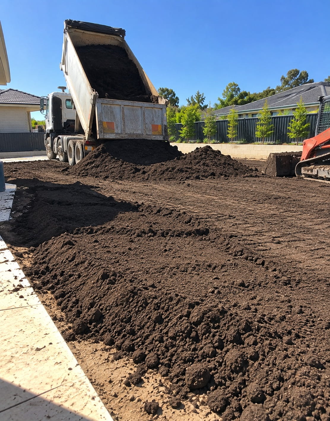 Fresh topsoil being spread for a new lawn in Perth